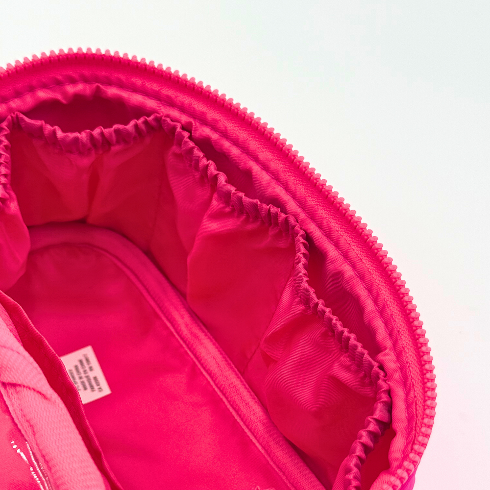 Close-up of a pink cozmetic case with a zipper on a white background